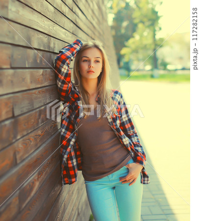 Portrait of beautiful caucasian blonde young woman in casual checkered shirt in the city 117282158