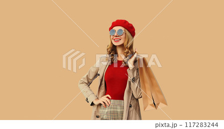 Autumn portrait of beautiful happy smiling young woman with shopping bags wearing red french beret 117283244