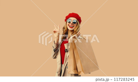 Autumn portrait of beautiful happy smiling young woman with shopping bags wearing red french beret Autumn portrait of beautiful happy smiling young woman with shopping bags wearing red french beret 117283245