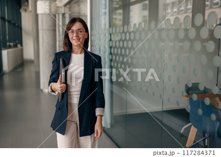 A confident businesswoman is presenting technology in a modern office environment A confident businesswoman is presenting technology in a modern office environment 117284371