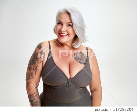 Confident Plus-Size Woman in Swimsuit against White Studio Background 117285204