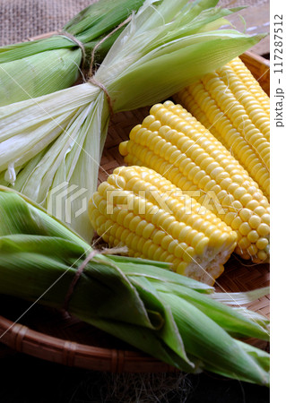 fresh corn on the cob wrapped in green husks just harvest from organic farming, farm to table, maize is food that nutrition and good for eyes 117287512