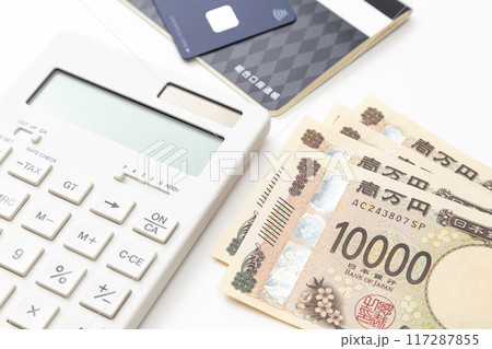 白背景に電卓と預金通帳と一万円 117287855