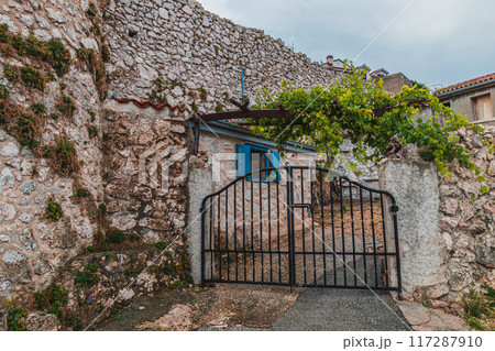 Old wall and house with courtyard in historical city Vrbnik Croatia 27.06.2024 117287910