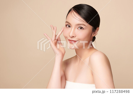 Beautiful young asian woman with clean fresh skin on beige background, Face care, Facial treatment, Cosmetology, beauty and spa, Asian women portrait. Beautiful young asian woman with clean fresh skin on beige background, Face care, Facial treatment, Cosmetology, beauty and spa, Asian women portrait. 117288498