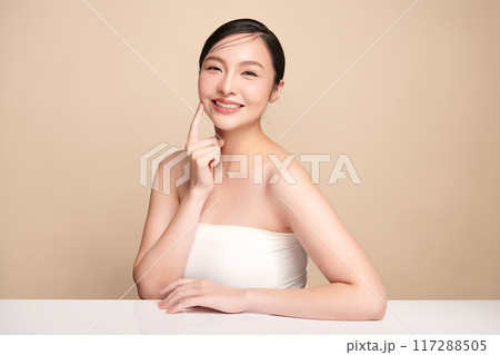 Beautiful young asian woman with clean fresh skin on beige background, Face care, Facial treatment, Cosmetology, beauty and spa, Asian women portrait. Beautiful young asian woman with clean fresh skin on beige background, Face care, Facial treatment, Cosmetology, beauty and spa, Asian women portrait. 117288505