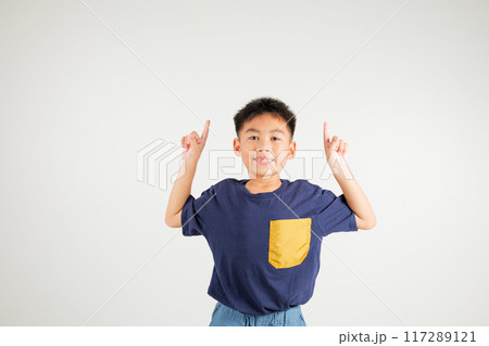 Asian happy portrait cute young kid boy makes gesture fingers point upwards above presenting product something, studio shot isolated on white background, primary children man smile Asian happy portrait cute young kid boy makes gesture fingers point upwards above presenting product something, studio shot isolated on white background, primary children man smile 117289121