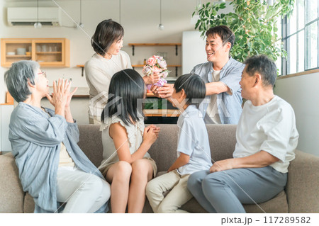 家のソファで家族団欒する三世代家族・ファミリー（母の日） 117289582