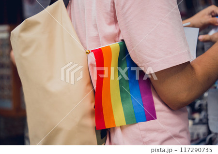Person holding a rainbow flag at LGBTQ pride Person holding a rainbow flag at LGBTQ pride 117290735