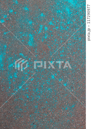 Multi-colored dry blue paints on gray asphalt. Powder coating at holi festival. Vertical photo. Multi-colored dry blue paints on gray asphalt. Powder coating at holi festival. Vertical photo. 117290977