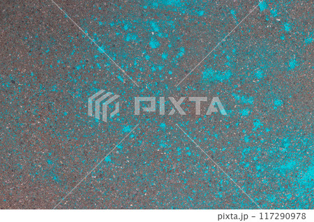 Multicolored dry blue paints on gray asphalt. Powder coating at the Holi festival. Place for inscription. Multicolored dry blue paints on gray asphalt. Powder coating at the Holi festival. Place for inscription. 117290978