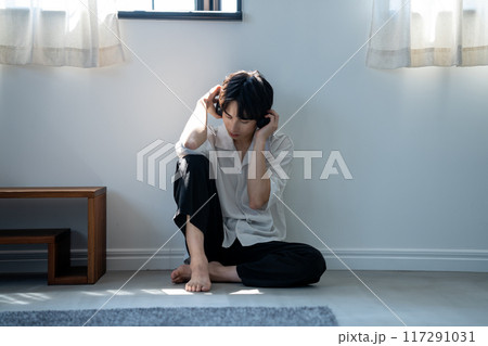 ヘッドホンで音楽を聴く若い男性 117291031