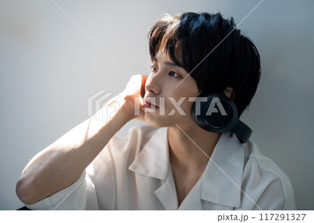 ヘッドホンで音楽を聴く若い男性 117291327