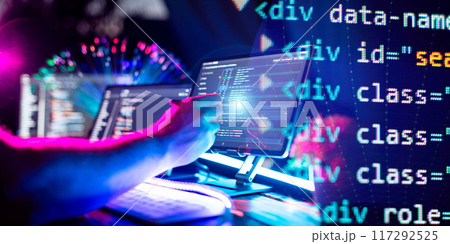 Programmer manually working with program code on a computer at night in a data center Programmer manually working with program code on a computer at night in a data center 117292525