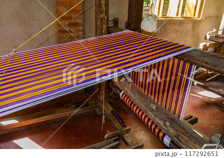 Cotton weaving on a traditional wooden handloom 117292651