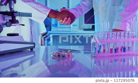Researchers collaborate in a laboratory, analyzing chemical substances and discussing advancements in medicine. 117295076