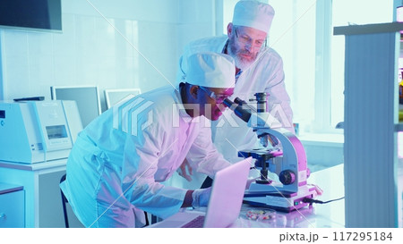 A chemist conducts analysis on chemical compounds using advanced equipment in a modern laboratory filled with vibrant technology. A chemist conducts analysis on chemical compounds using advanced equipment in a modern laboratory filled with vibrant technology. 117295184