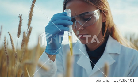 Female Scientist Examining Chemical Sample in Test Tube 117296401