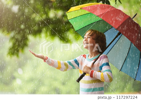Child playing in rain. Kid jumping in puddle. Child playing in rain. Kid jumping in puddle. 117297224