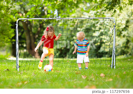 Child playing football. Kids play soccer. 117297656