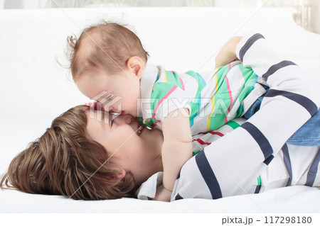 Kids playing on parents bed 117298180