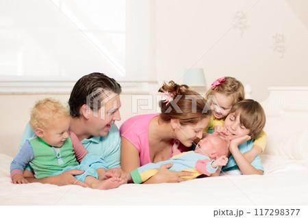 Family with kids playing with newborn baby 117298377