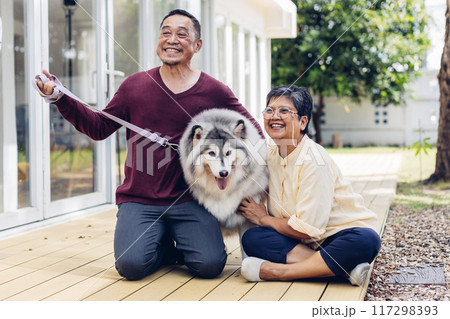 Happy Asian senior couple petting their dog outside home 117298393