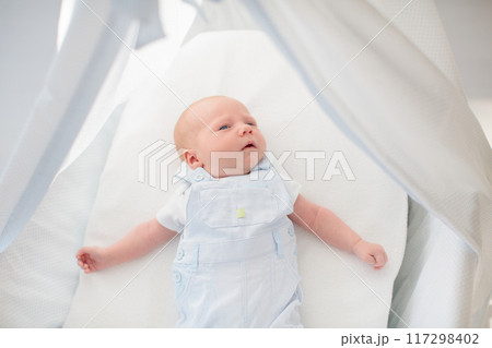 Little baby on white bed 117298402