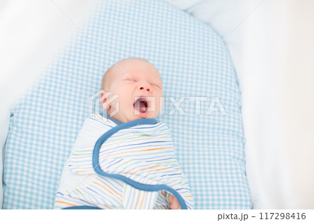 Swaddling newborn child. Baby in swaddle blanket. Swaddling newborn child. Baby in swaddle blanket. 117298416