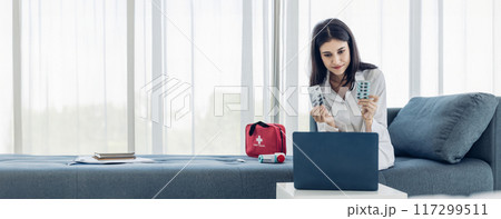 Woman measuring blood pressure by using digital sphygmomanometer at home 117299511