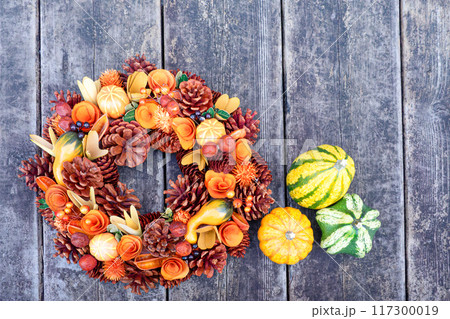 ウッドデッキに置かれたハロウィンのカボチャ 117300019