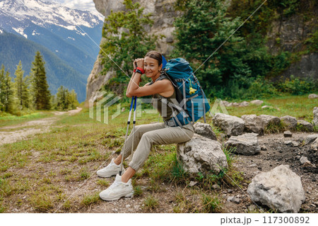 A Relaxing Hiker Enjoys the Scenic Beauty of a Majestic Mountain Landscape with a Backpack A Relaxing Hiker Enjoys the Scenic Beauty of a Majestic Mountain Landscape with a Backpack 117300892