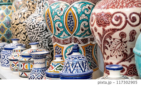 Colorful Moroccan pottery and ceramics displayed outside shops in the souks, showcasing traditional designs and craftsmanship. Colorful Moroccan pottery and ceramics displayed outside shops in the souks, showcasing traditional designs and craftsmanship. 117302905