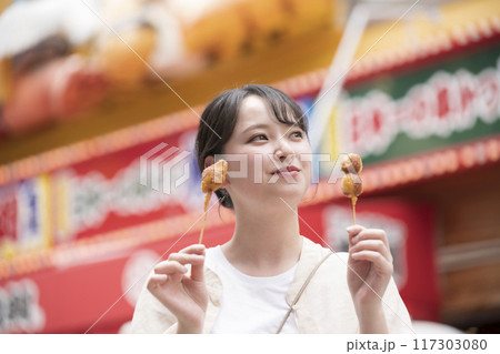 串カツを持っている若い女性 串カツを持っている若い女性 117303080