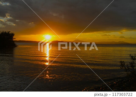 霞ヶ浦に沈みゆく太陽と遠景に浮かぶ筑波山 霞ヶ浦に沈みゆく太陽と遠景に浮かぶ筑波山 117303722