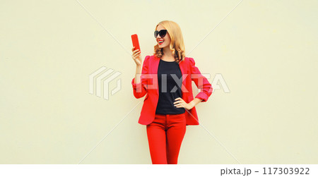 beautiful smiling elegant lady woman with smartphone wearing red business blazer on white background 117303922