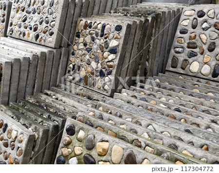 A pile of concrete tiles filled with rocks on top 117304772