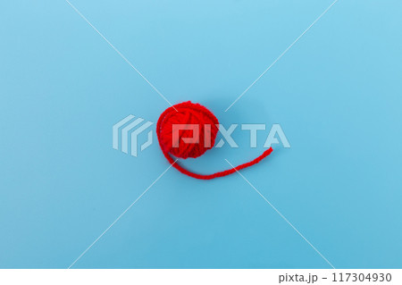 a red ball of yarn on a blue surface, minimalism, miniature product photo, close-up product photo, very accurate photo, product introduction photo 117304930