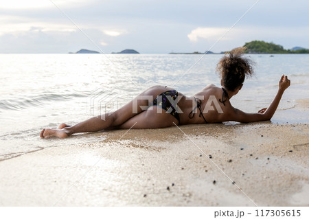 Beautiful girl on sun tanning in a tropical beach 117305615