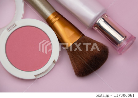 Coral blush, fuchsia eyeshadows and makeup brush on pink background, cosmetics texture 117306061