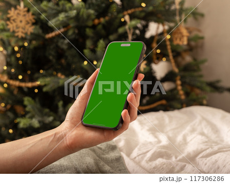 Lodz Poland July 20 2024 Hand holding mobile phone mockup, iphone screen mock up, Christmas holiday 117306286