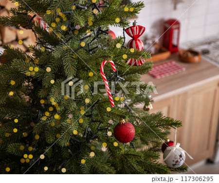 Decorated Christmas tree with garland light and candy cane and kitchen Decorated Christmas tree with garland light and candy cane and kitchen 117306295