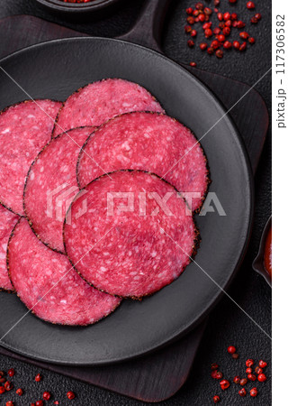 Delicious smoked salami sausage sliced with salt, spices and herbs 117306582