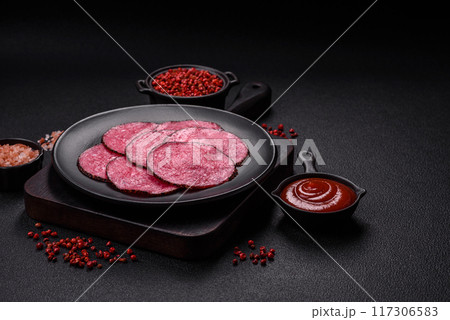 Delicious smoked salami sausage sliced with salt, spices and herbs Delicious smoked salami sausage sliced with salt, spices and herbs 117306583