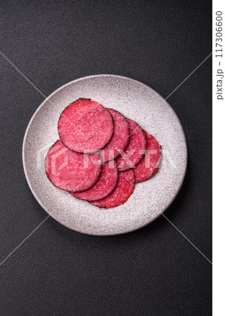 Delicious smoked salami sausage sliced with salt, spices and herbs Delicious smoked salami sausage sliced with salt, spices and herbs 117306600