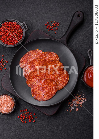 Delicious smoked pepperoni sausage sliced with salt, spices and herbs 117306633