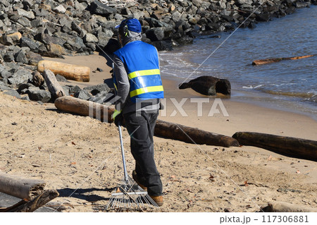 Man working, park worker cleaning sand on New York City beach Man working, park worker cleaning sand on New York City beach 117306881