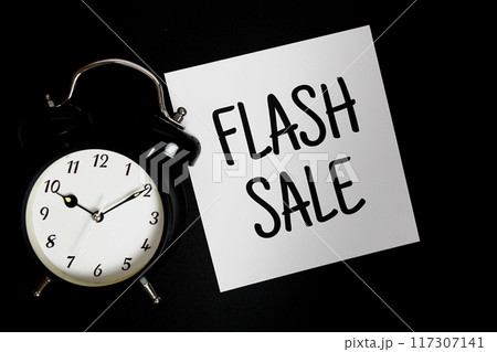 Flash sale text on paper card with alarm clock top view on black background Flash sale text on paper card with alarm clock top view on black background 117307141
