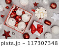 Red and white Christmas baubles in a box flat lay. Merry Christmas and Happy New Year seasons greetings card. Copy space. Festive full frame 117307348