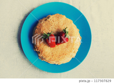 Cooking, stack of pancakes with strawberries on blue plate Cooking, stack of pancakes with strawberries on blue plate 117307829